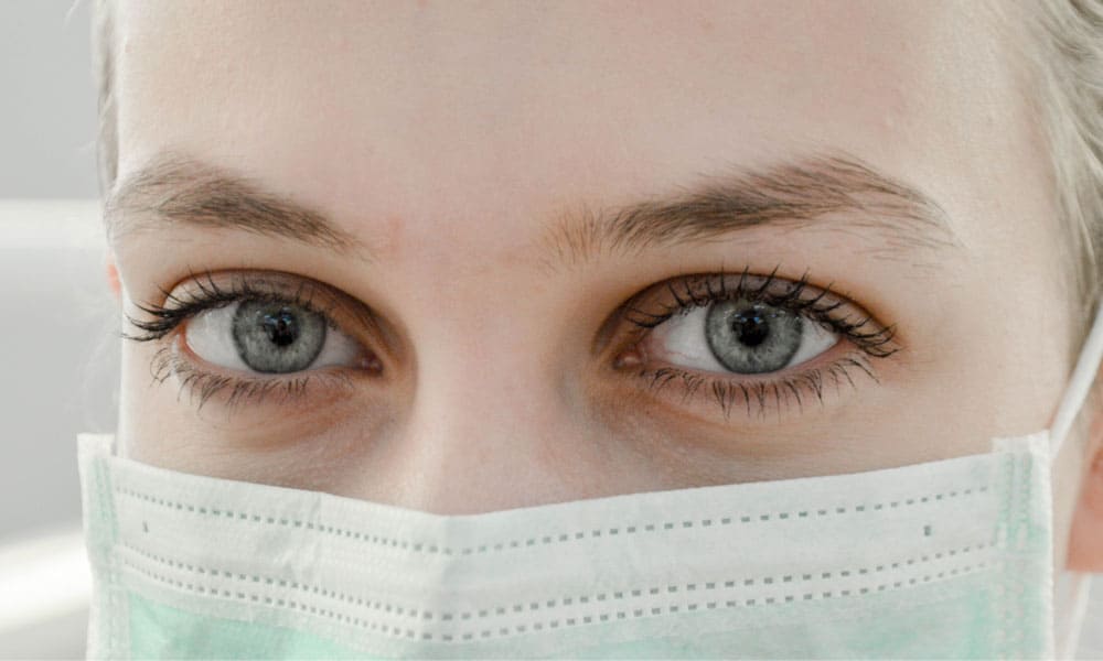An up close look at a healthcare workers eyes above an N95 Maske