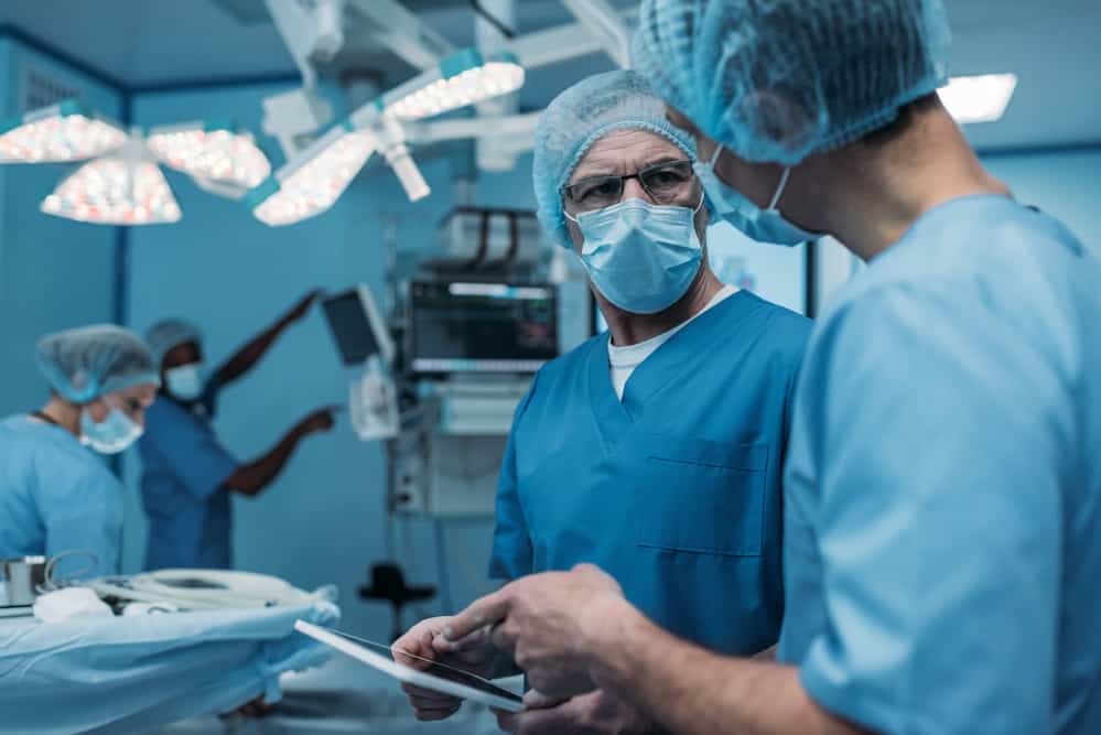 Doctors in an operating room using a tablet